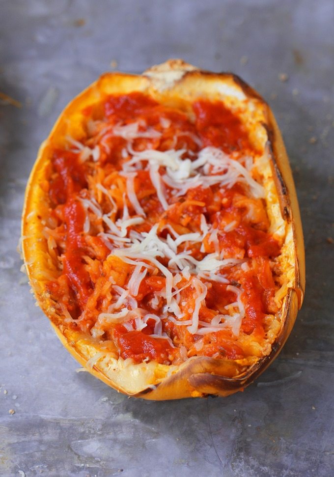 Cheesy Baked Spaghetti Squash Parmigiana - 5 ingredients, simple comfort food... A satisfying & super healthy weeknight meal, without all the extra fat and calories weighing you down. @choccoveredkt https://chocolatecoveredkatie.com/2016/03/10/spaghetti-squash-parmigiana-recipe-healthy-dinner/