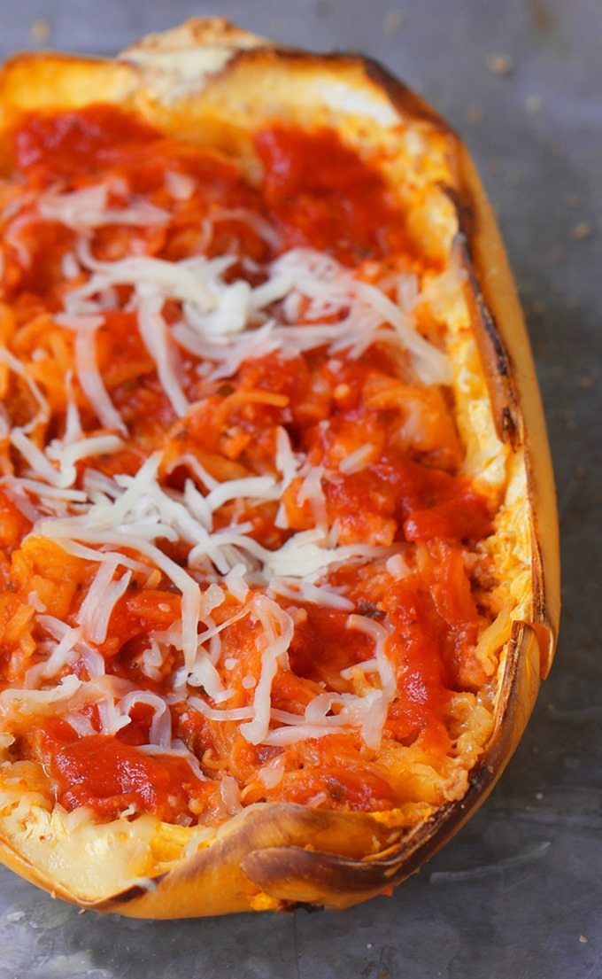 Cheesy Baked Spaghetti Squash Parmigiana - 5 ingredients, simple comfort food... A satisfying & super healthy weeknight meal, without all the extra fat and calories weighing you down. @choccoveredkt https://chocolatecoveredkatie.com/2016/03/10/spaghetti-squash-parmigiana-recipe-healthy-dinner/
