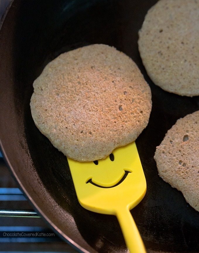 Frying latkes in a skillet, puffs of flour and oil cobwebbing out onto the  stovetop. The cook flipping the potato pancakes with a spatula, kids  eagerly peeking inside the skillet. Generative AI