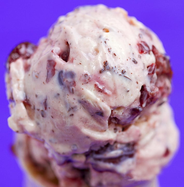 A scoop of vegan Cherry Garcia Frozen Yogurt with chocolate chunks and cherries