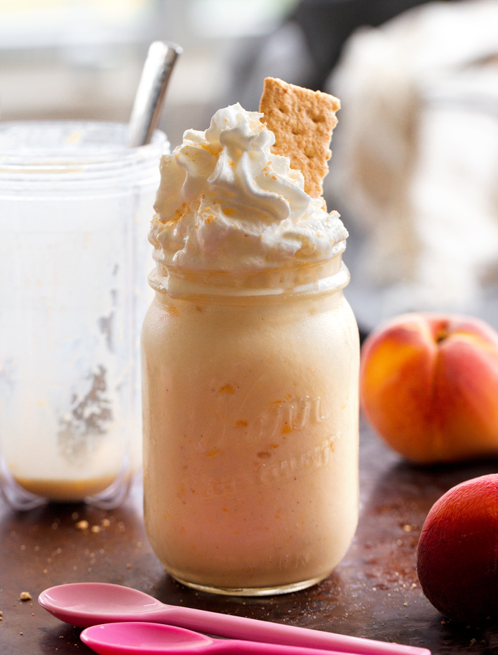Healthy Peach Smoothie With Frozen Yogurt, topped with whipped cream and graham cracker crumbs