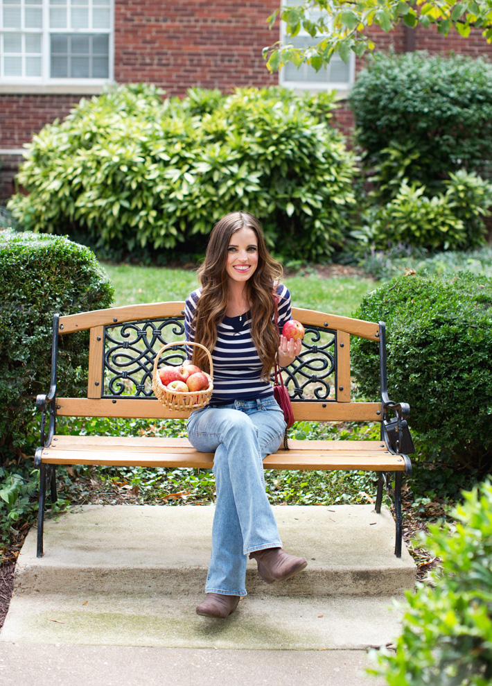 Girl With Apples In Basket On Bench